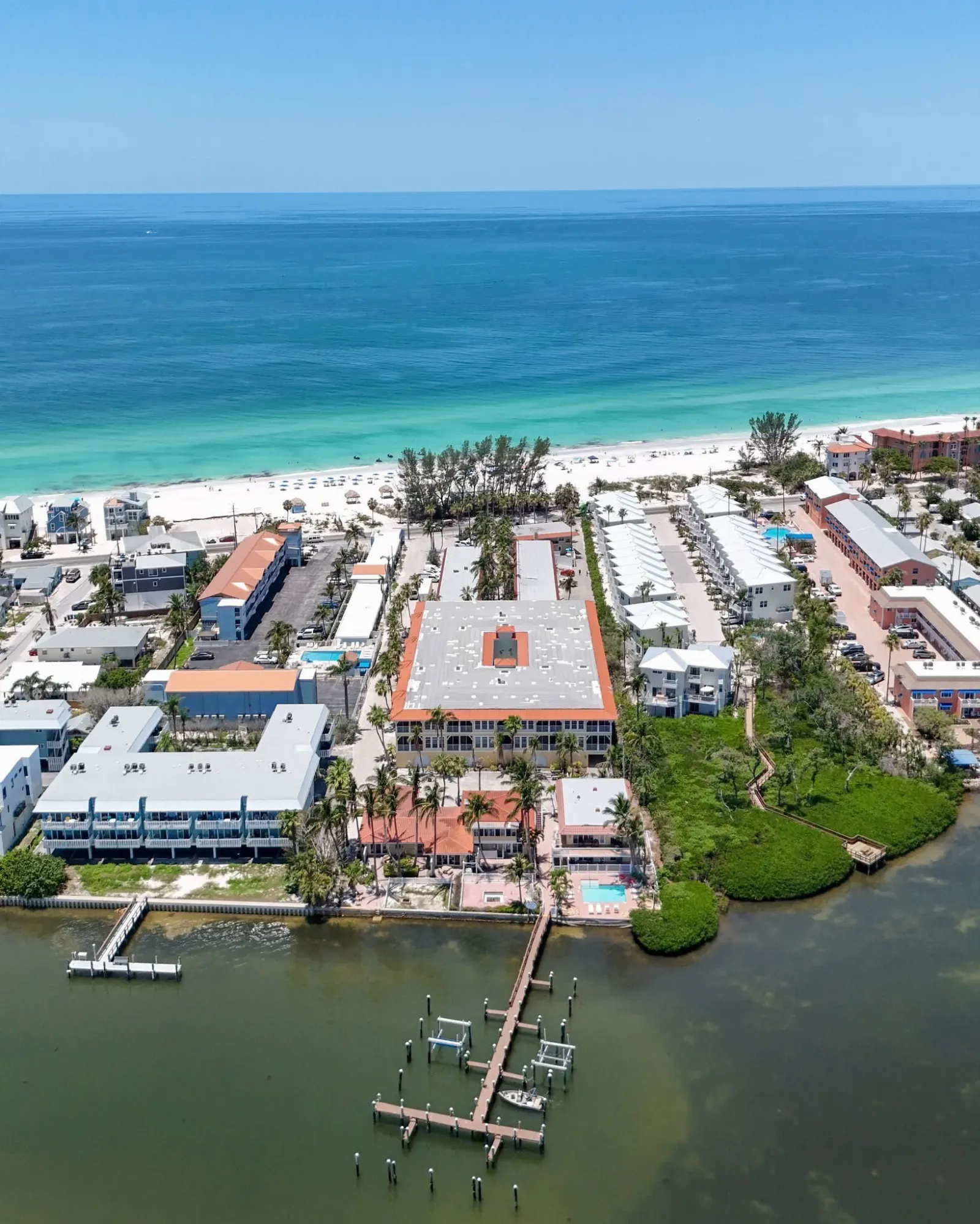 Aerial view of Tortuga Inn Resort between the Gulf beach and Sarasota Bay and Bradenton Beach, FL