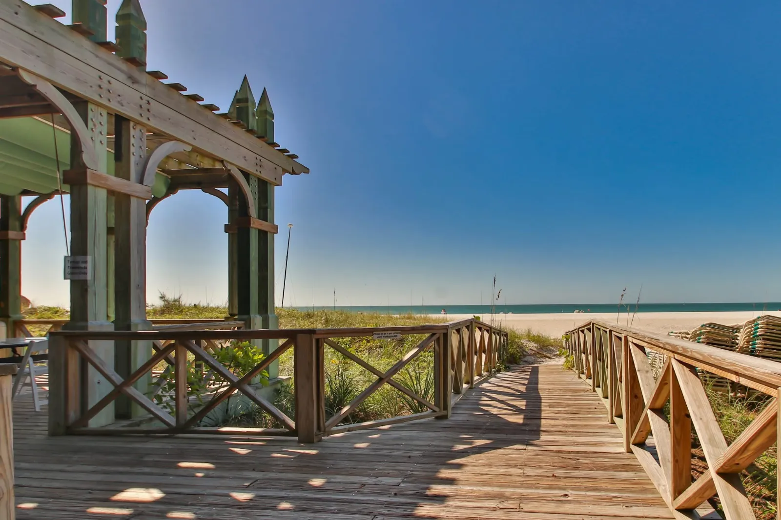 Covered wooden pergola with outdoor seating overlooking the private beach path
